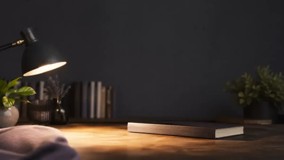 Книги по гипнозу на столе в круге света настольной лампы.