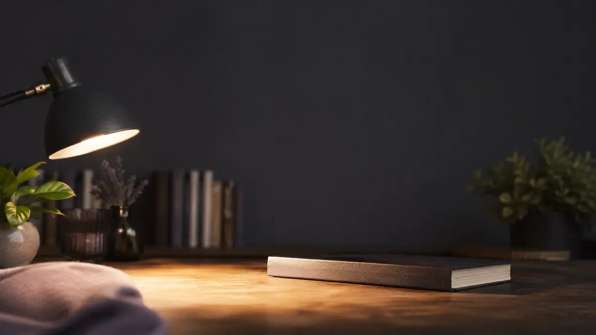 Книги по гипнозу на столе в круге света настольной лампы.